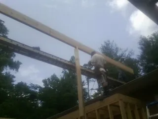 Carpenter setting a ridge beam over a new addition frame — Ice Dam Removal by Roofing Brothers in Oakley